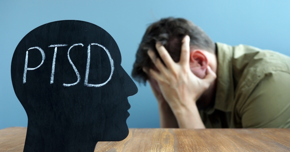 A teen boy with his head in his hands in distress, with a silhouette labeled PTSD, representing Teen PTSD.