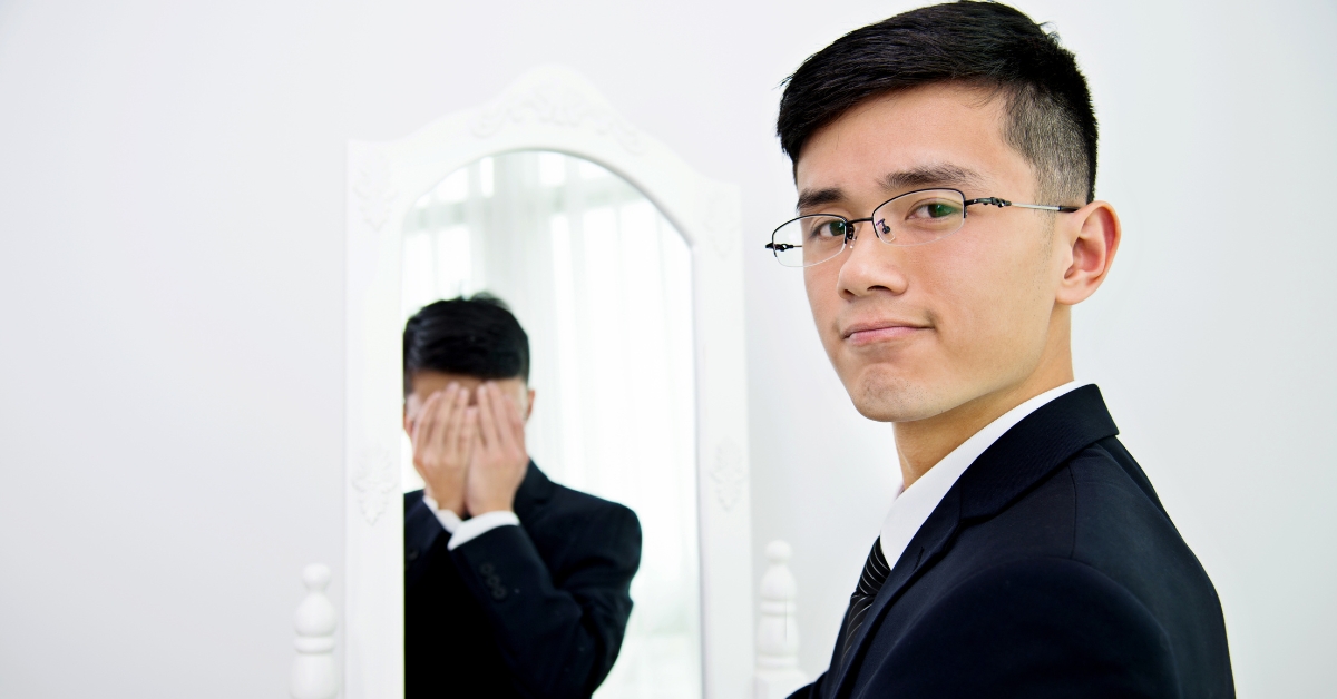 A teen boy in glasses standing confidently, with his reflection in the mirror showing distress, representing Teen Bipolar.