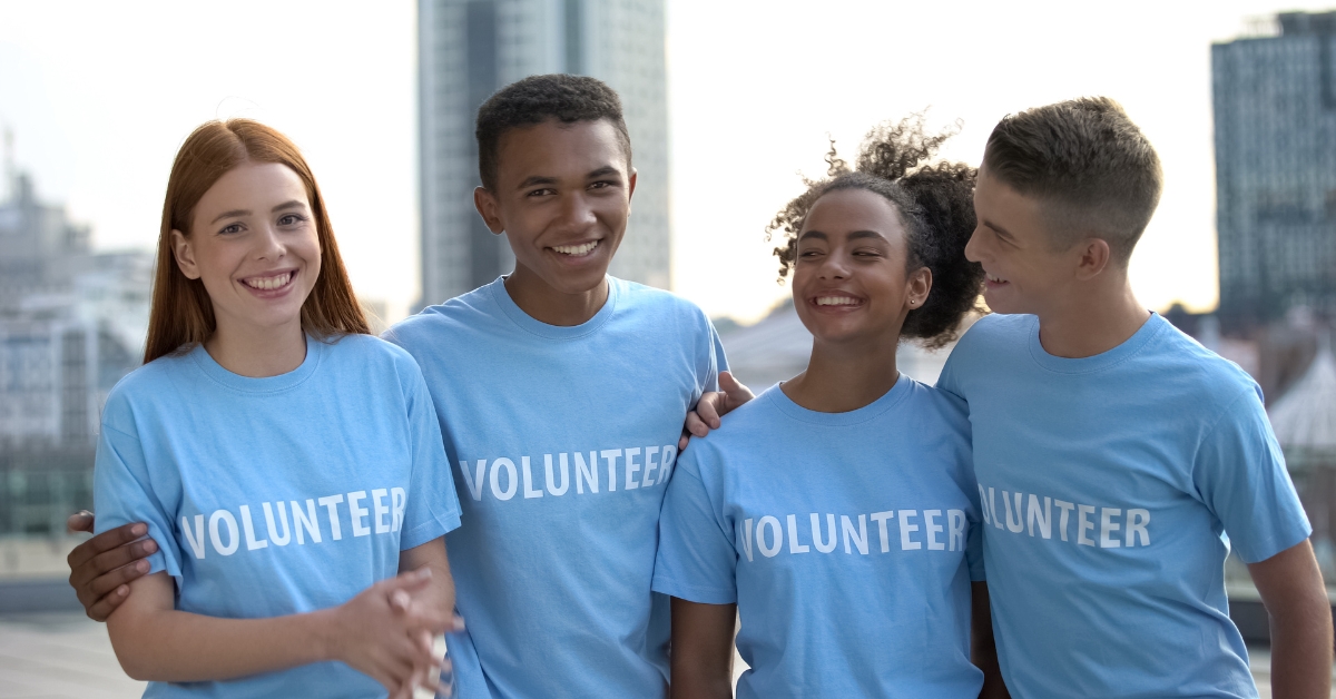 Four teenagers in "Volunteer" shirts smiling, illustrating choosing the right teen recovery program.