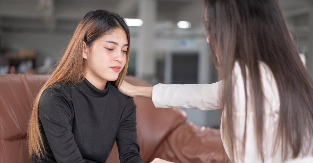 A teen girl receiving comforting support from another person, addressing academic stress in teens.