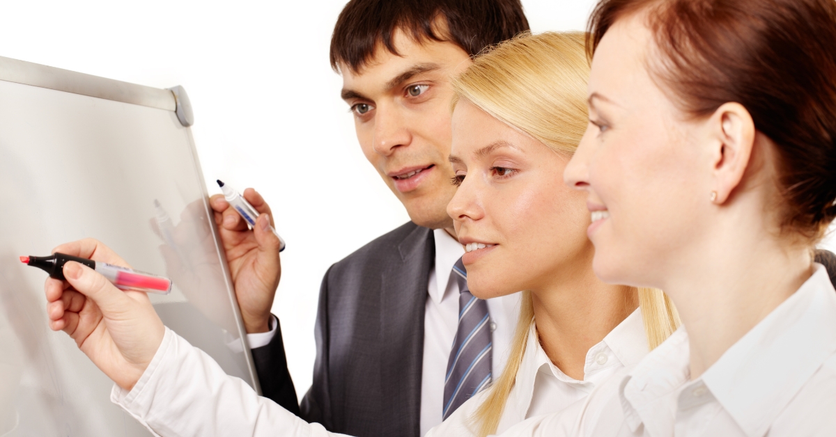 Three professionals collaborating on a whiteboard, illustrating an Anxiety Treatment Plan example.