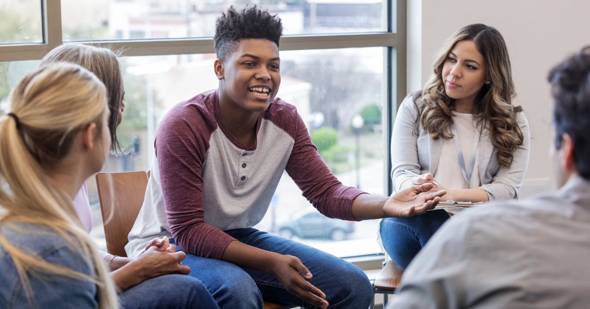 A teen participating in a group therapy session, illustrating the concept of teen recovery naturally.