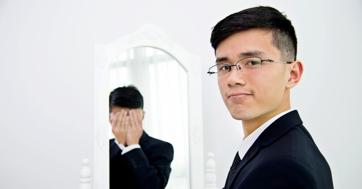 Young man in front of a mirror, reflecting the risks of substance use in bipolar disorder.