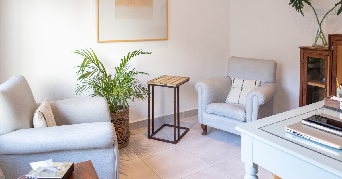 A cozy, well-furnished room with armchairs and plants, depicting a teen mental health treatment center.