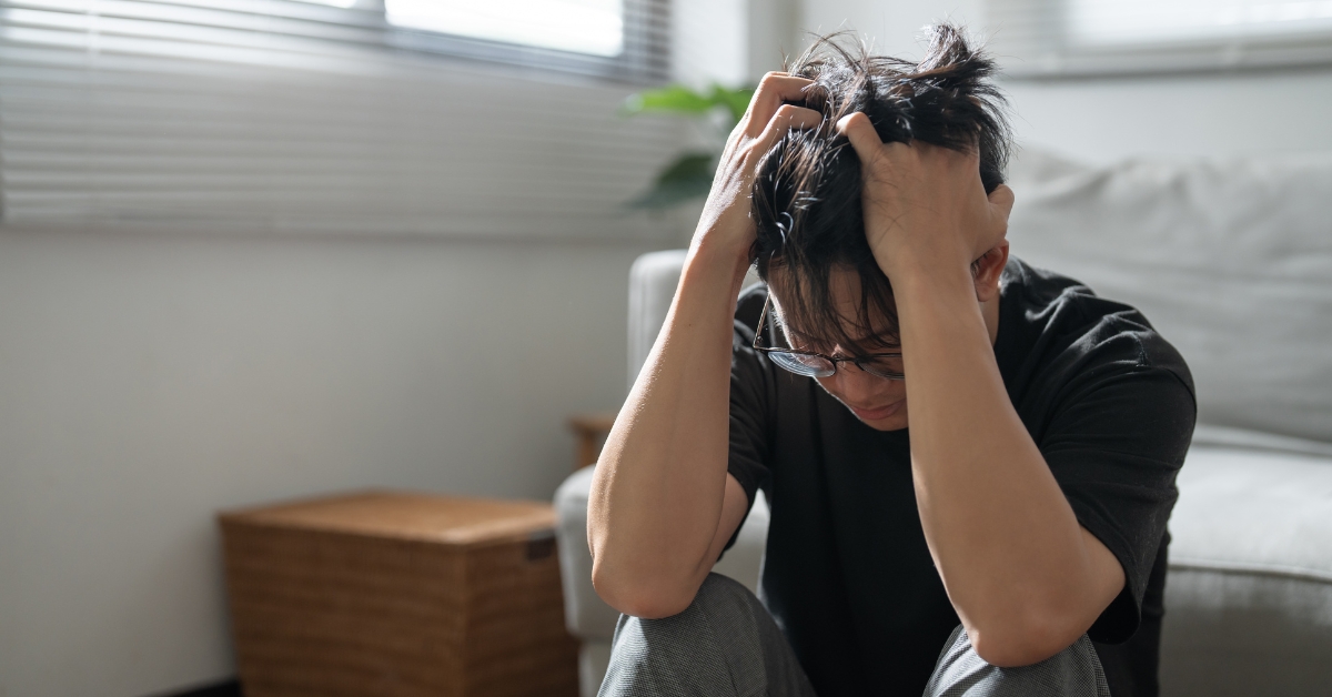 Distressed man holding his head, illustrating what Generalized Anxiety Disorder is.