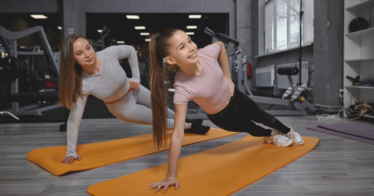 Two young women exercising on mats, illustrating Exercise Addiction: When Fitness Becomes Unhealthy.