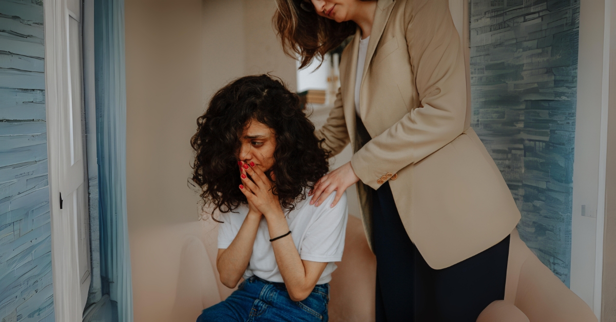 Woman comforting a distressed young woman, highlighting trauma's role in developing anxiety.