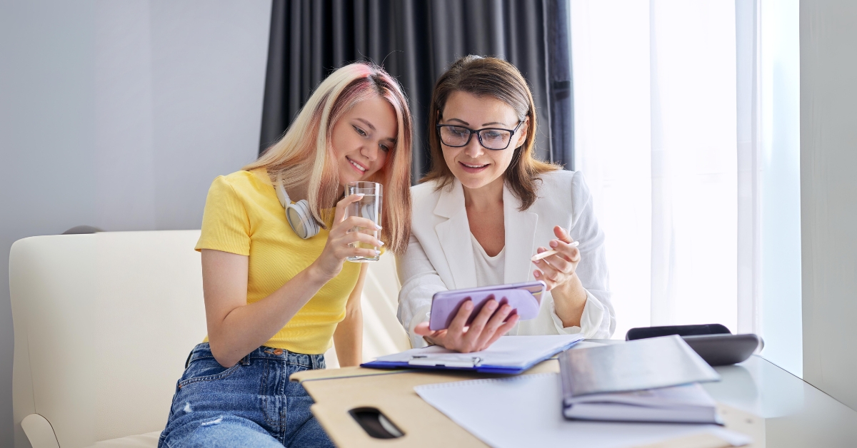 Mother and teenage daughter bonding over a phone, illustrating treating anxiety in teenage girls.