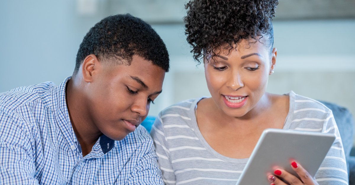 A woman and teen discuss something on a tablet, illustrating telehealth options for anxiety treatment.