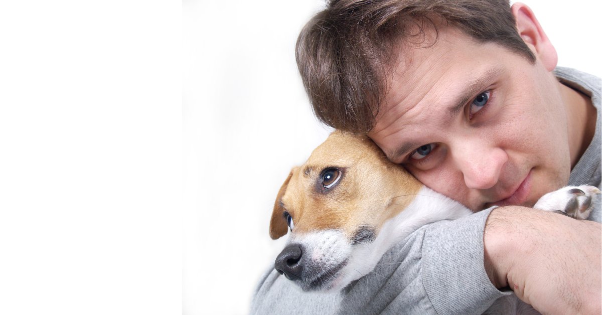 A man cuddles with his dog, illustrating the calming effects of pet therapy for anxiety relief.