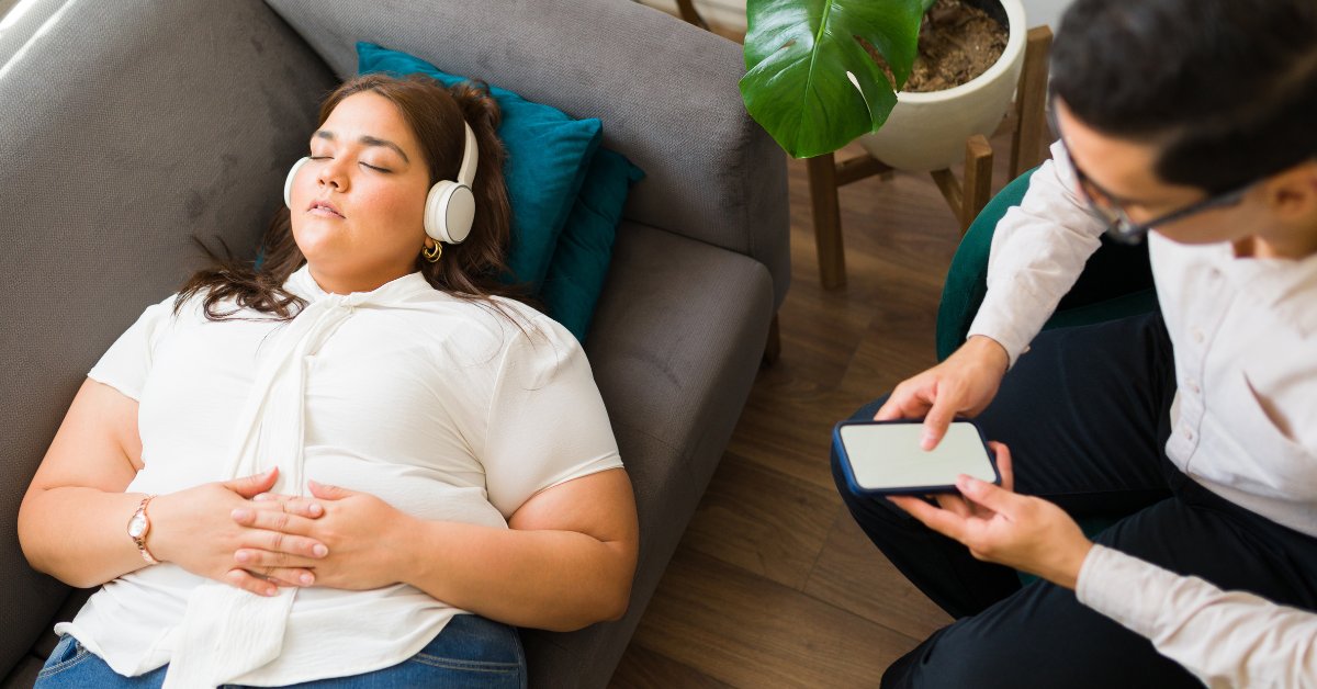 A woman listens to music with headphones during a therapy session, highlighting music therapy for anxiety disorders.