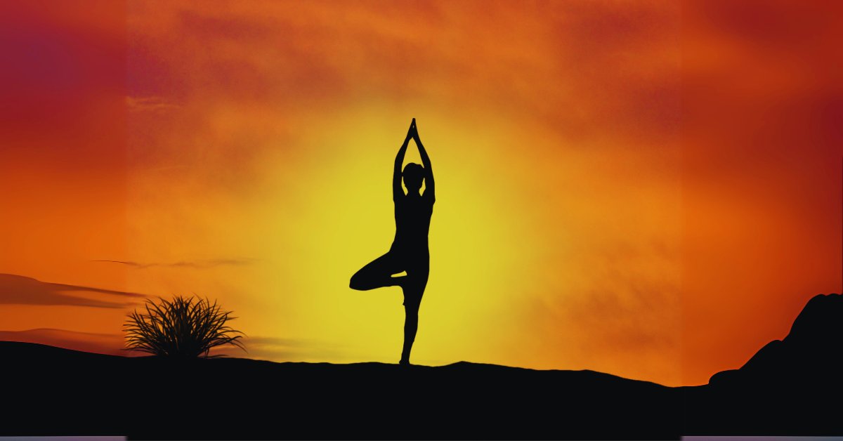 A silhouette of a person doing yoga at sunset, illustrating yoga for anxiety: poses and practices.